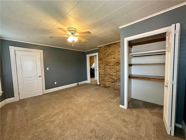 unfurnished bedroom featuring crown molding, baseboards, carpet floors, and ceiling fan