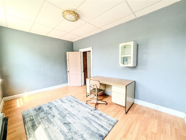 home office featuring light wood-type flooring and a drop ceiling