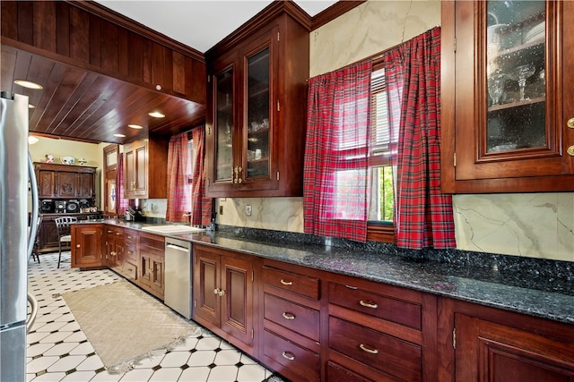 kitchen featuring appliances with stainless steel finishes, sink, dark stone counters, and decorative backsplash