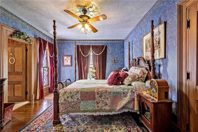 bedroom featuring a textured ceiling, ceiling fan, ornamental molding, and hardwood / wood-style floors