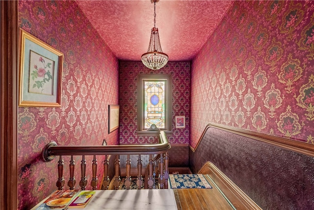 interior space featuring a textured ceiling, hardwood / wood-style flooring, and an inviting chandelier