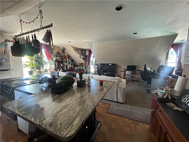 kitchen with a textured ceiling, range with electric stovetop, and dark parquet floors