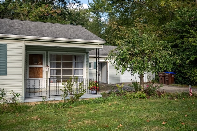 view of front of house with a garage, a porch, and a front lawn