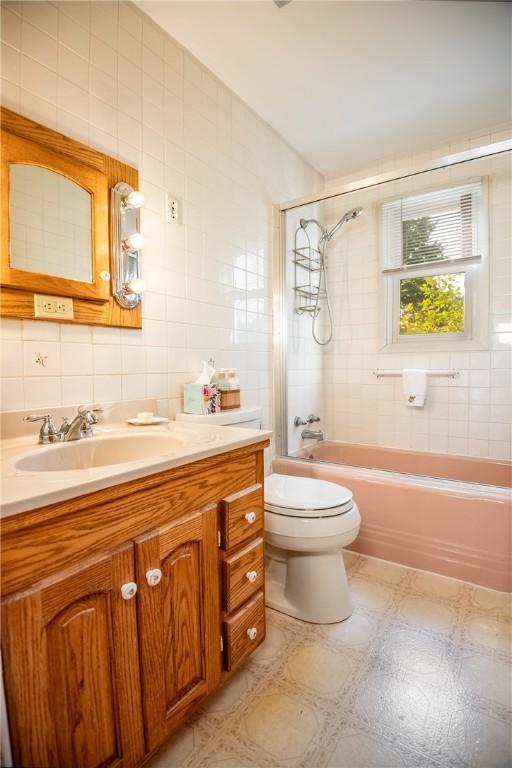 314 Lunn Blvd, Farrell, PA 16121 - bathroom with vanity, tile walls, toilet, bathtub / shower combination, and decorative backsplash