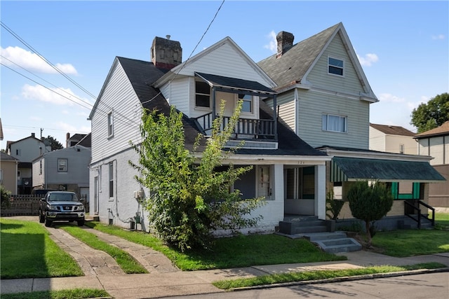 view of front of house featuring a balcony, a front yard, and a porch