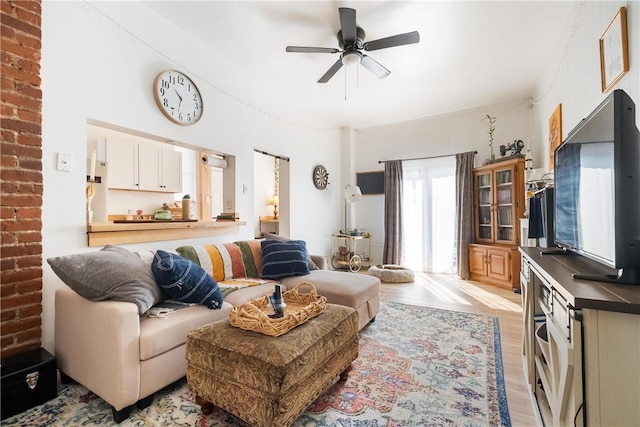 living room with light hardwood / wood-style flooring and ceiling fan