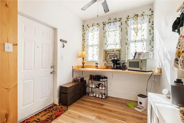 entryway featuring a healthy amount of sunlight, cooling unit, a ceiling fan, and light wood-style flooring