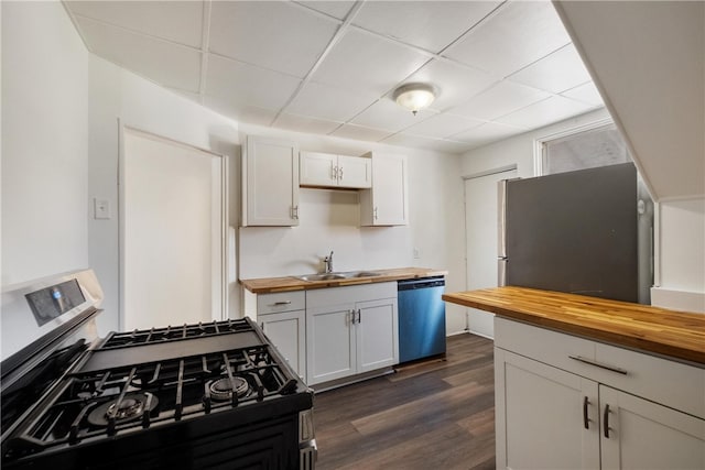 kitchen with butcher block countertops, dark hardwood / wood-style flooring, stainless steel appliances, sink, and white cabinets