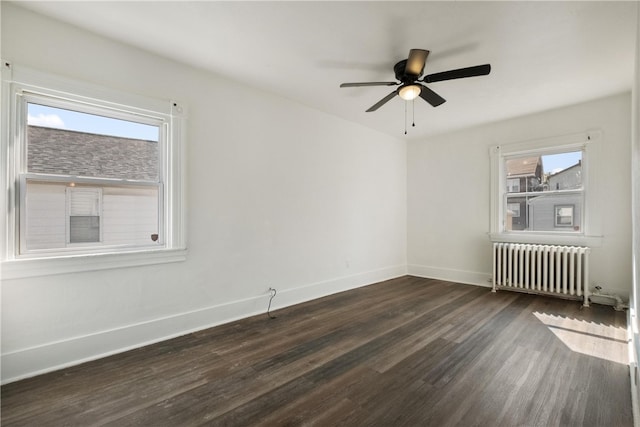 spare room featuring dark hardwood / wood-style flooring, ceiling fan, and radiator