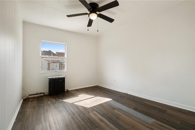 empty room featuring dark hardwood / wood-style flooring, ceiling fan, and radiator heating unit