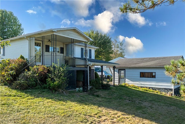 rear view of house featuring a yard and a porch