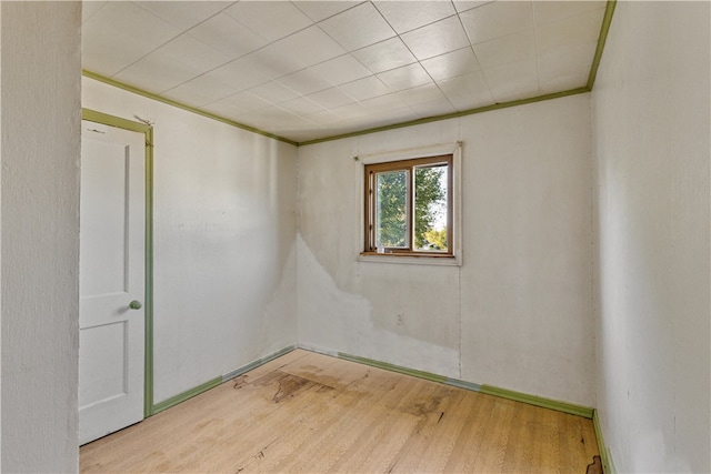 spare room featuring crown molding and light hardwood / wood-style floors