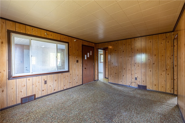 entrance foyer featuring carpet flooring and wood walls