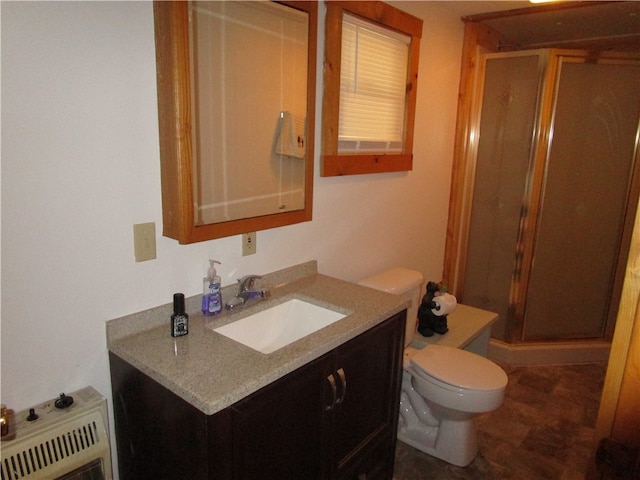 bathroom featuring a shower with door, vanity, and toilet