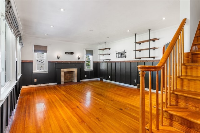 17 Long St, Hanover Twp Wsh, PA 15021 - unfurnished living room featuring wood finished floors, a fireplace, a wainscoted wall, stairs, and crown molding