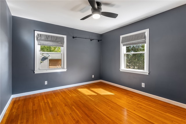 empty room with hardwood / wood-style floors and ceiling fan