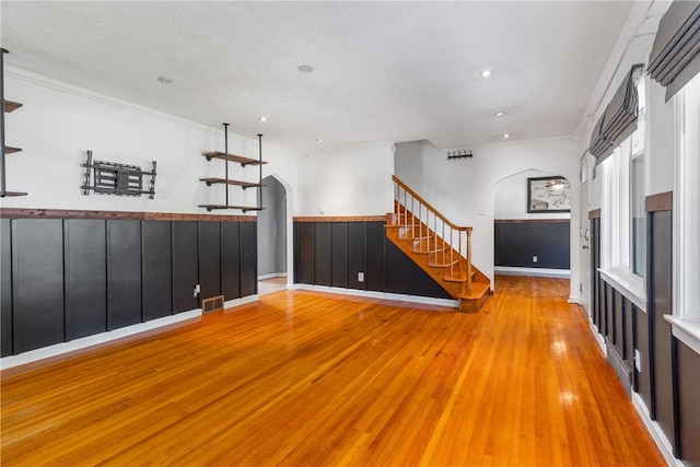 spare room featuring hardwood / wood-style floors, crown molding, and a textured ceiling