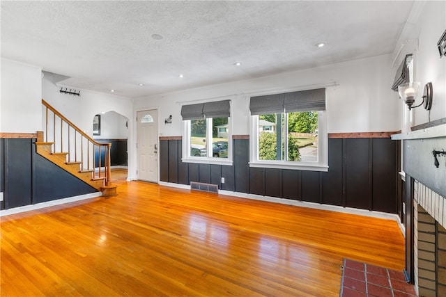 17 Long St, Hanover Twp Wsh, PA 15021 - unfurnished living room featuring wood finished floors, stairway, a wainscoted wall, arched walkways, and a textured ceiling