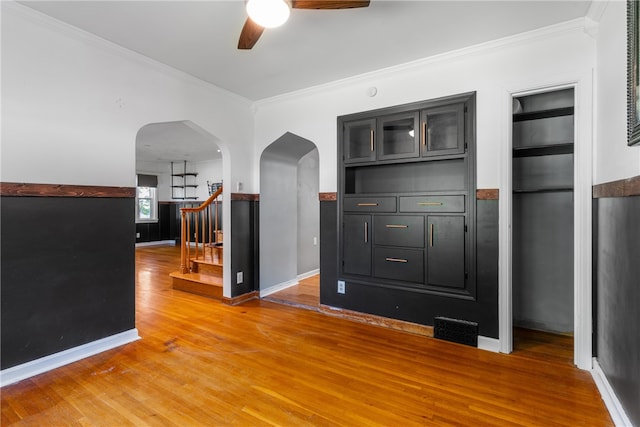 interior space featuring crown molding, wood-type flooring, and ceiling fan