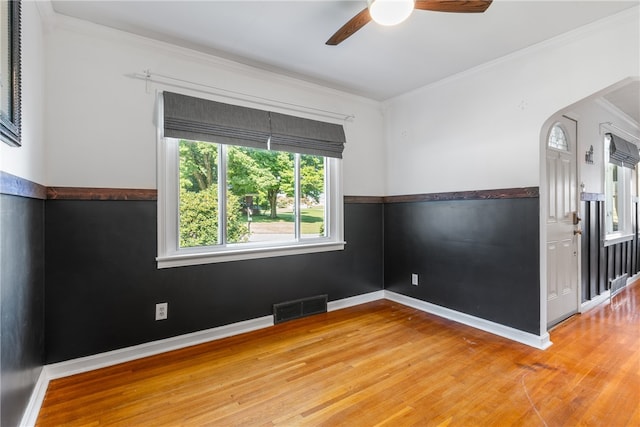 empty room with hardwood / wood-style floors, crown molding, and ceiling fan