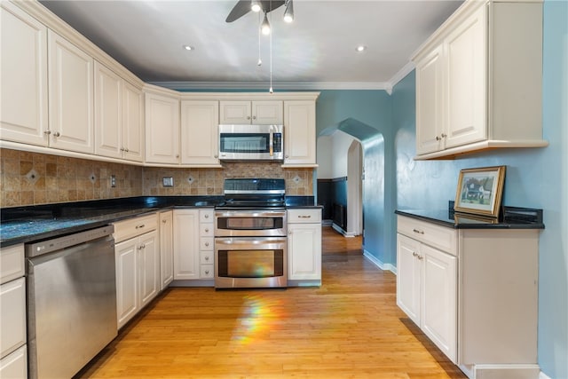 kitchen with ornamental molding, appliances with stainless steel finishes, light hardwood / wood-style floors, and ceiling fan