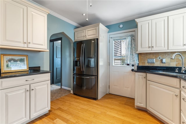 kitchen with sink, light hardwood / wood-style flooring, white cabinets, and refrigerator with ice dispenser