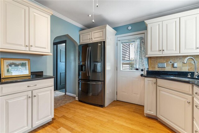 17 Long St, Hanover Twp Wsh, PA 15021 - kitchen with black fridge, light wood finished floors, ornamental molding, a sink, and tasteful backsplash