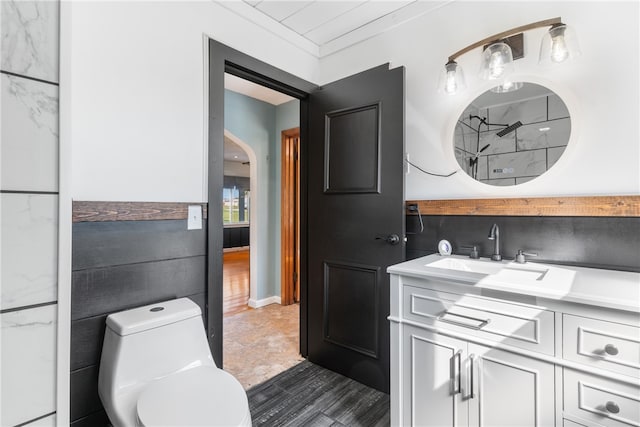 bathroom featuring tile walls, vanity, ornamental molding, and toilet