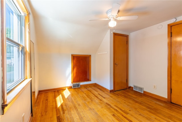 bonus room with lofted ceiling, light hardwood / wood-style floors, a healthy amount of sunlight, and ceiling fan