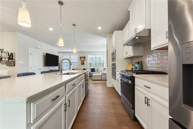 kitchen featuring a kitchen island with sink, white cabinetry, sink, light stone countertops, and appliances with stainless steel finishes