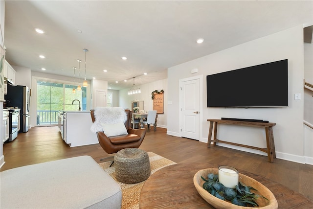 living room featuring dark hardwood / wood-style flooring and an inviting chandelier