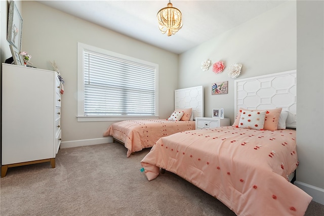 carpeted bedroom featuring an inviting chandelier