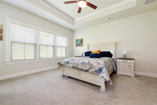 bedroom featuring a tray ceiling, crown molding, light carpet, and ceiling fan