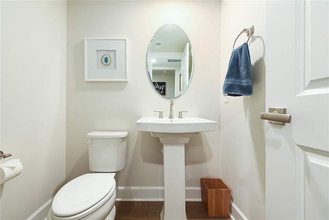 bathroom with wood-type flooring and toilet