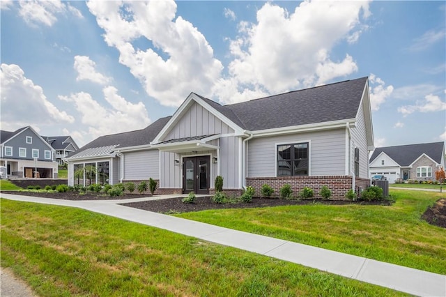 409 Spruce Ln, North Strabane, PA 15317 - view of front of property with french doors, board and batten siding, a front yard, brick siding, and cooling unit