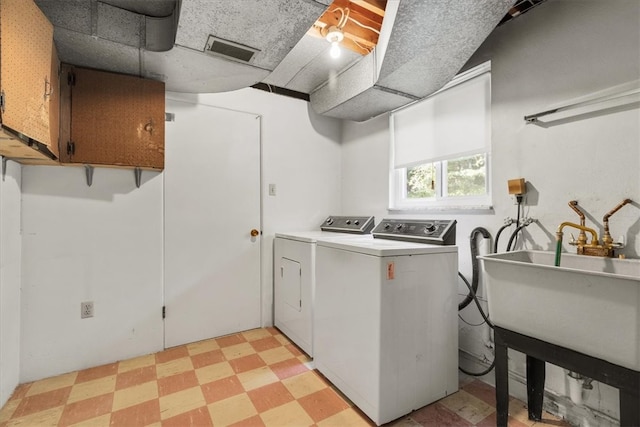 laundry area featuring cabinets, sink, and independent washer and dryer