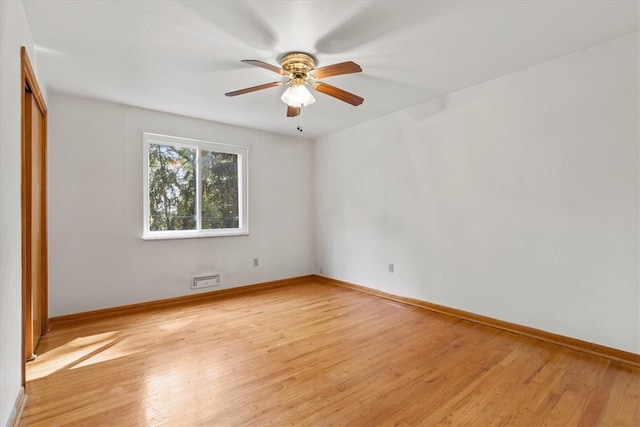 empty room with ceiling fan and light hardwood / wood-style flooring