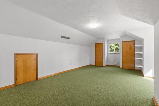 bonus room featuring carpet, vaulted ceiling, and a textured ceiling