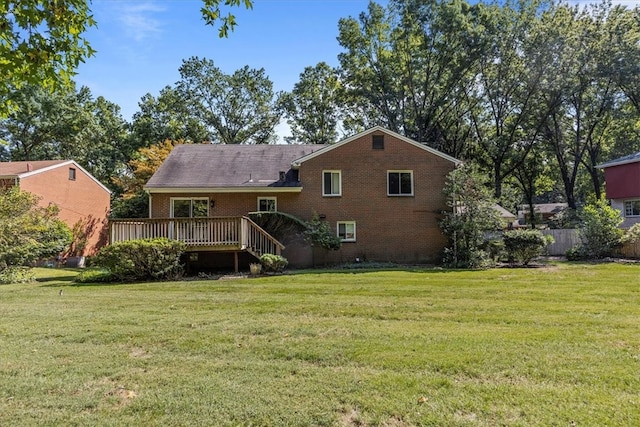 rear view of house featuring a yard and a deck