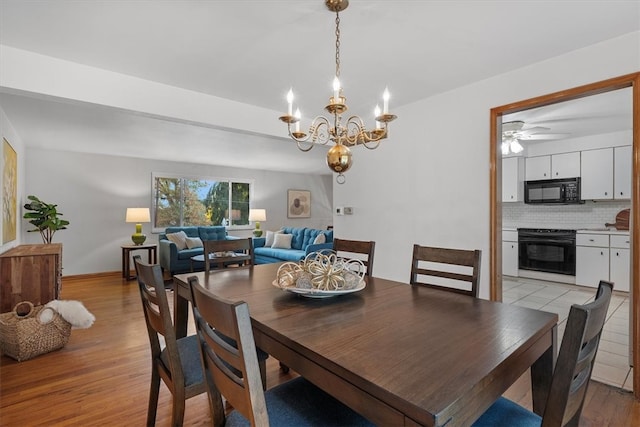 dining room with light wood-type flooring and ceiling fan with notable chandelier