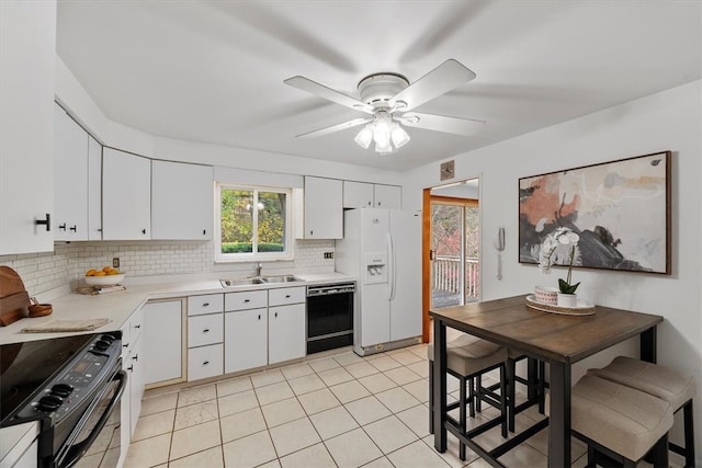 kitchen featuring decorative backsplash, black appliances, sink, light tile patterned flooring, and white cabinetry