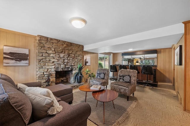 living room featuring a stone fireplace, wooden walls, and bar