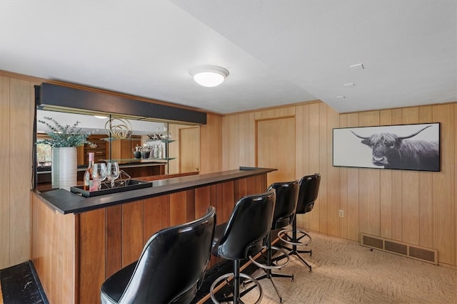 bar featuring light colored carpet and wooden walls