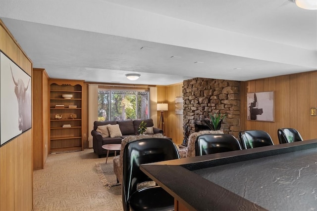 living room featuring a fireplace and wooden walls