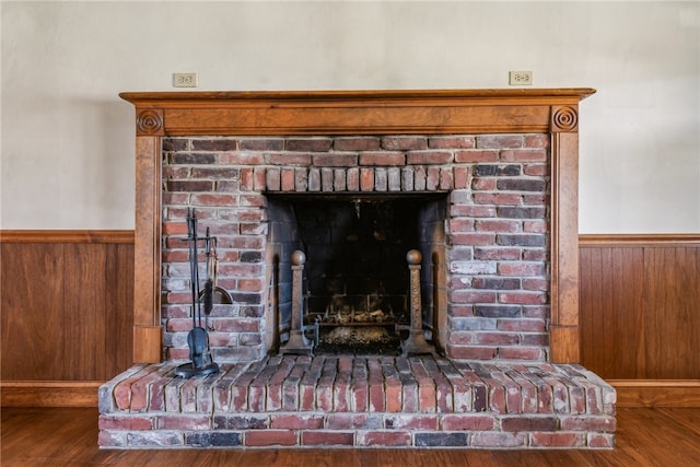 interior details featuring a fireplace, wood walls, and hardwood / wood-style flooring