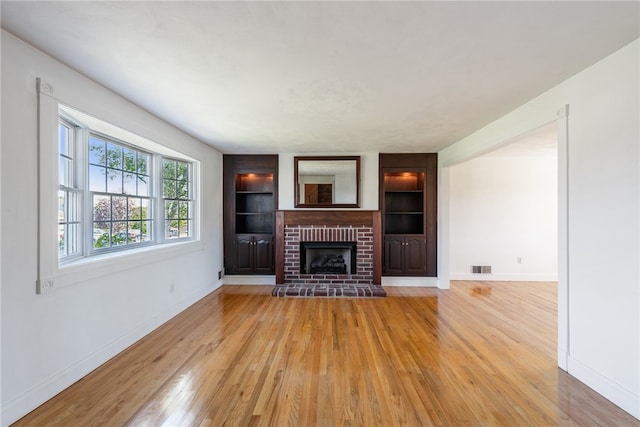 unfurnished living room featuring light hardwood / wood-style flooring and a fireplace