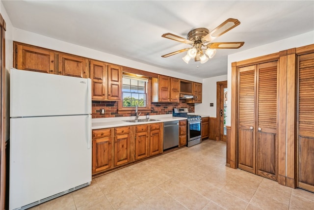 kitchen with ceiling fan, decorative backsplash, stainless steel appliances, ventilation hood, and sink