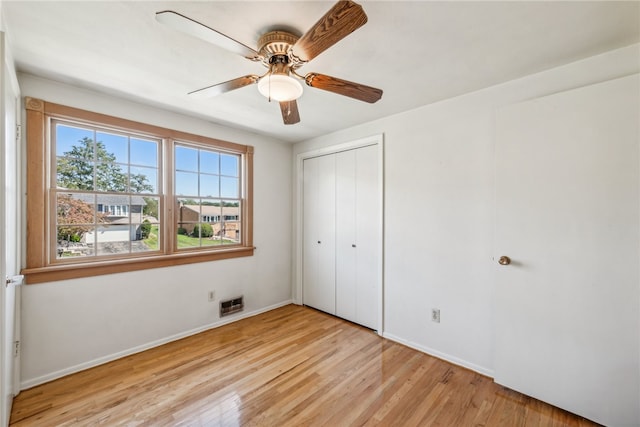 unfurnished bedroom featuring a closet, light hardwood / wood-style flooring, and ceiling fan