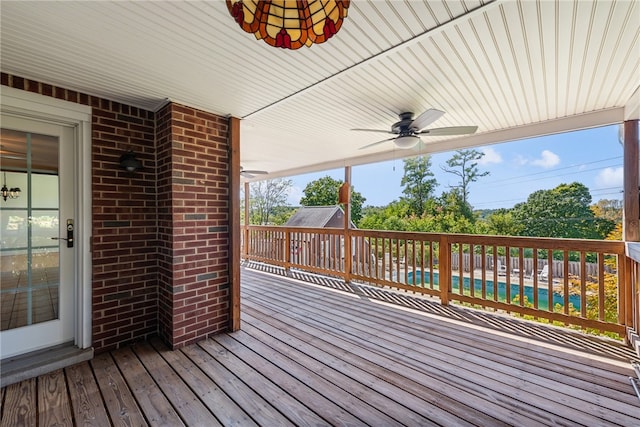 deck featuring ceiling fan and a swimming pool