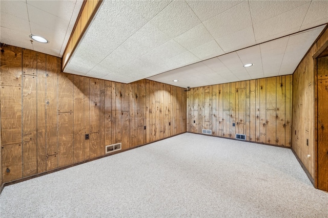 bonus room with carpet floors and wooden walls